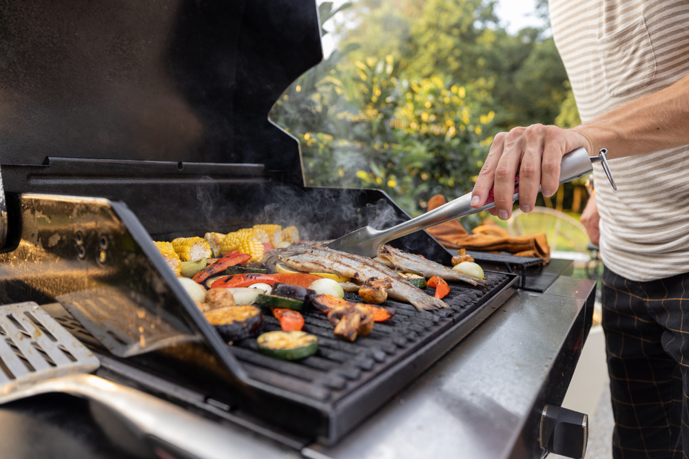 People,Grilling,Fish,And,Corn,On,A,Modern,Grill,Outdoors
